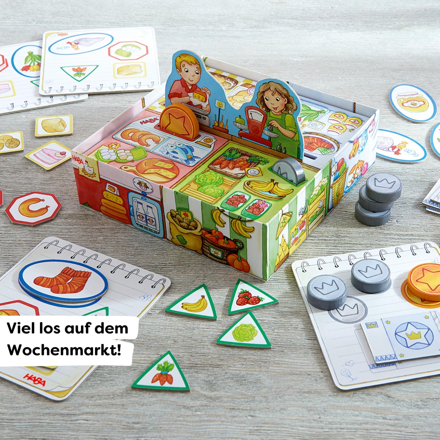 HABA Meine ersten Spiele Set de societate Cumpărături cu stand de piață 3D, bani de jucărie din lemn și liste de cumpărături de la 2 ani